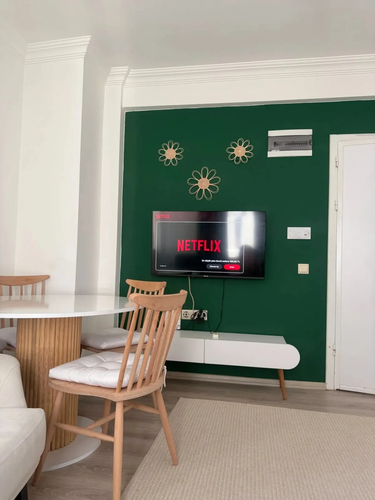 Sitting area with a green wall, a table and the kitchen